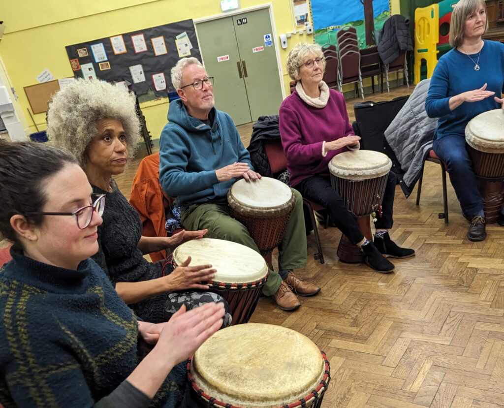 5 people playing African drums